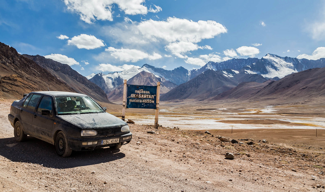 The Ak Baital Valley, Pamir Highway, means of transport, and Pik Agamau at far right.  