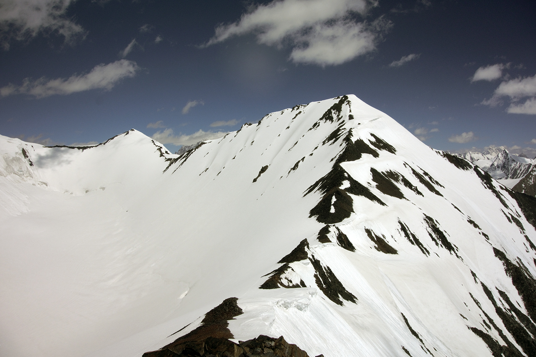 Looking north along the watershed ridge of the Thangman Glacier to Peak 6,200m (unclimbed) and, distant left, Manlung Kangri (6,207m). The first ascent of the latter was made via the snow face from the upper glacier.  