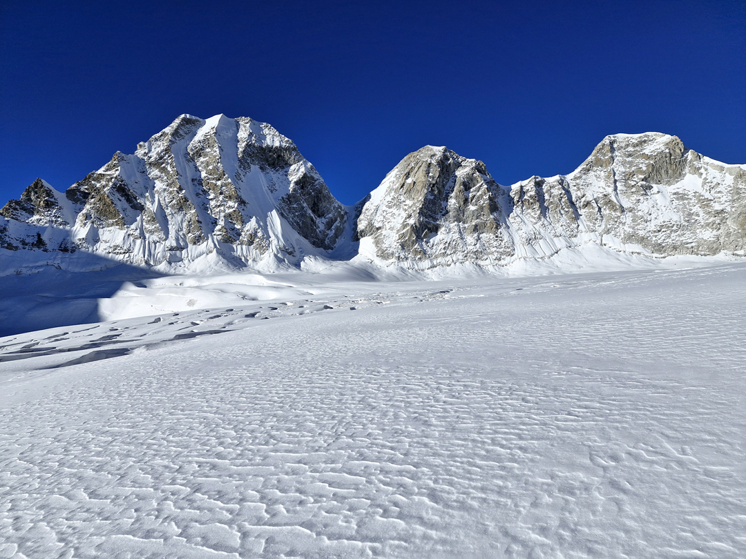 Referred to as the Trident peaks by the 2023 expedition that first explored the Angsi Glacier basin, these three summits along the south rim are (left to right) Peaks 6,119m, 6,085m, and Angsi Dong Dong. Both Peak 6,119m and Angsi Dong Dong were climbed in 2024.