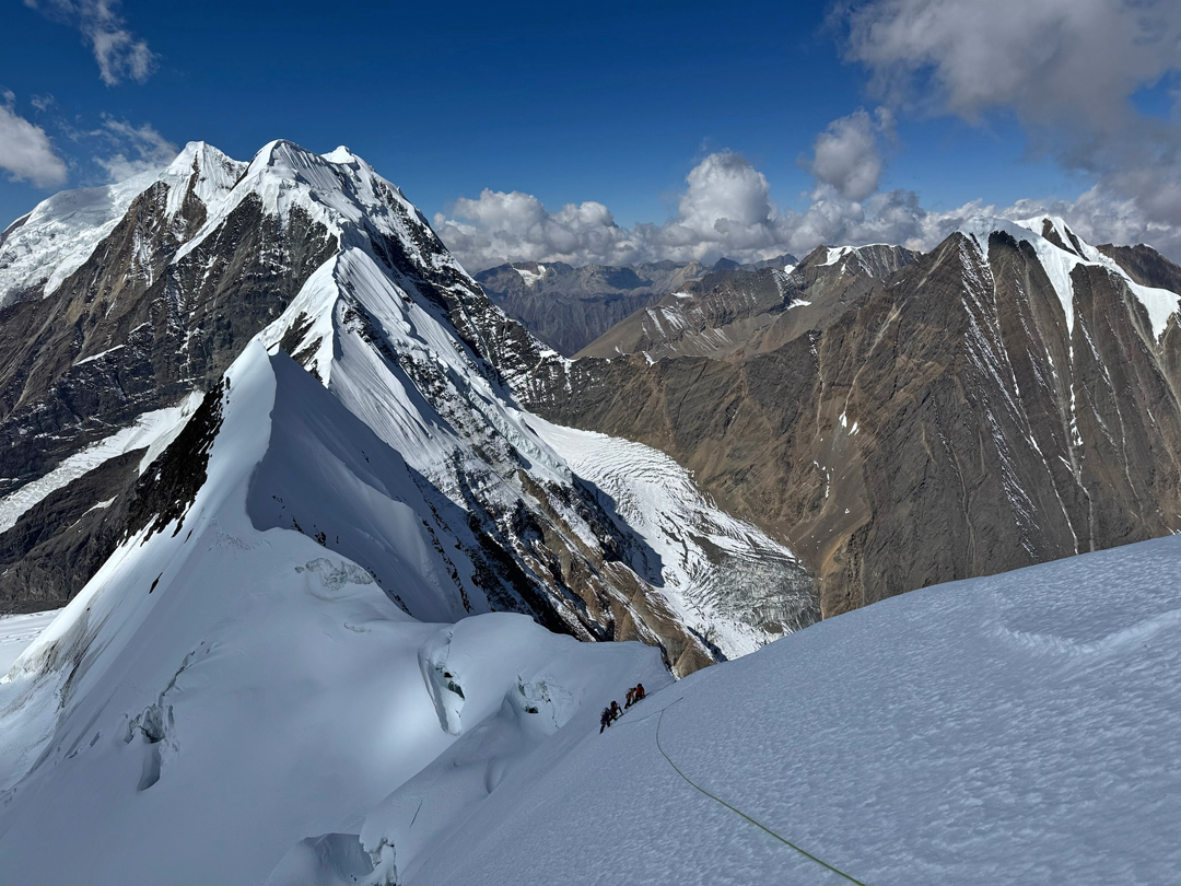 On the summit (west) ridge of Sanctuary Peak. In the background, the three high summits are the Patrasi Peaks, from left to right: Patrasi Main or West (6,521m), Patrasi Northeast (6,450m), and Patrasi Central or North-northeast (6,471m). Over to the right is the barely snowcapped Bhulu Lhasa (6,102m). 