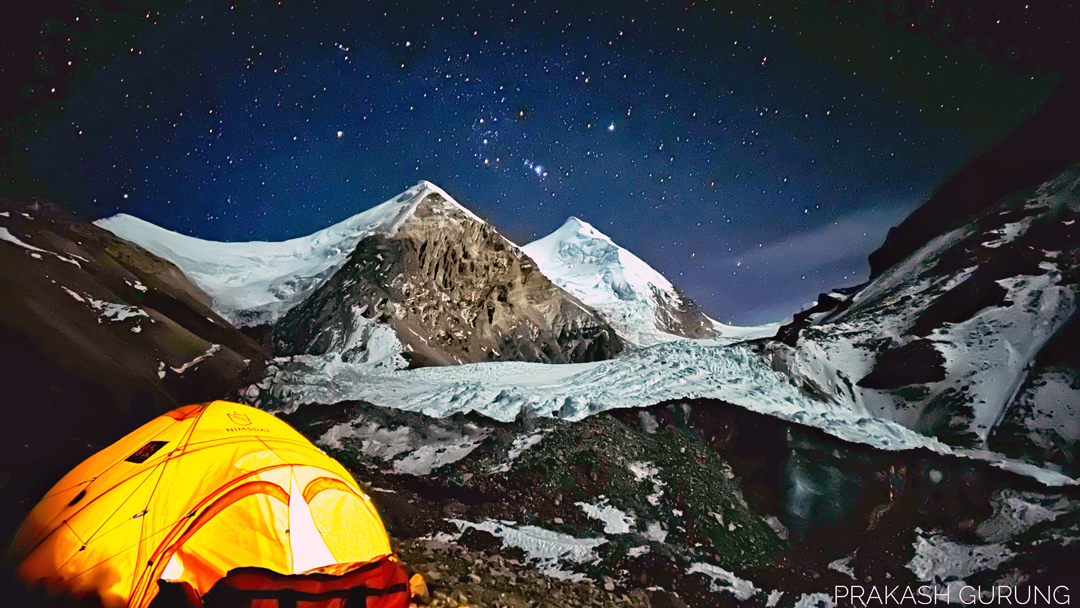 Camp below the snout of the glacier at the head of the Tange Khola valley, with Khumjungar on the right and the 6,655m northwest summit, with its rocky triangular face, to the left. The northwest face of Khumjungar points toward the camera. The route of the December 2023 ascent followed the glacier, which bends around to the left behind the mountain to reach the south-southwest face.  