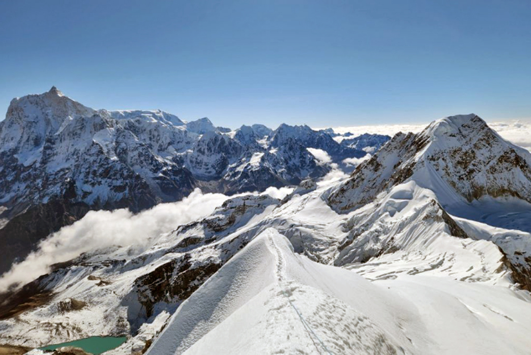 Looking down the south-southeast ridge of Sharphu III from near the base of the foresummit rock tower. The summit at far right is Sato Peak, and far left is Jannu.