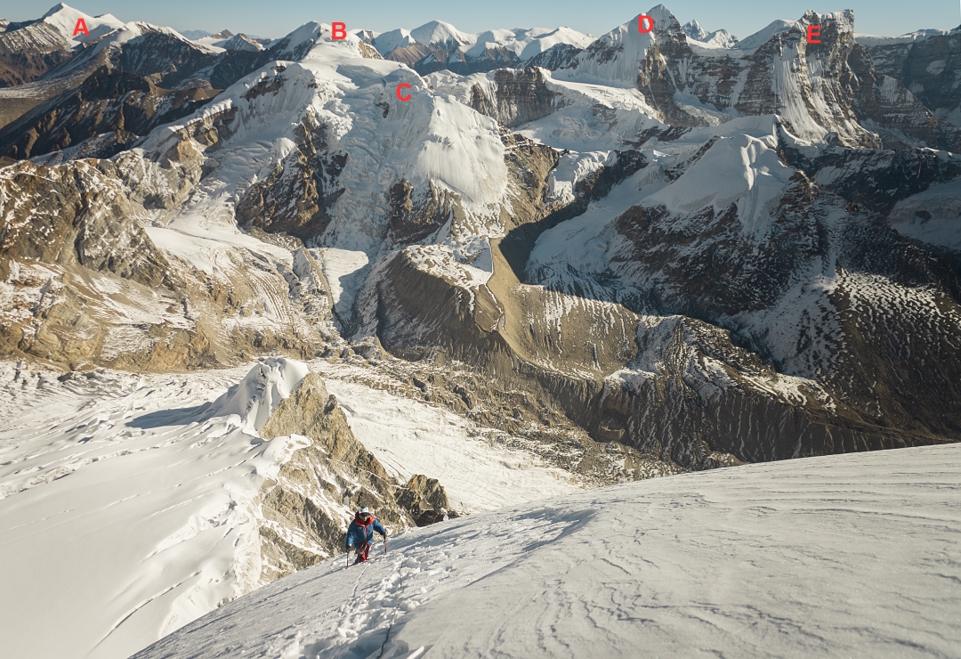 Akihiro Oishi on the summit slopes of Pandra, with a view to the northeast. (A) Peak 6,515m above the Zajingzhung Glacier in Tibet. (B) Dzanye (6,581m). (C) Peak 6,466m with the upper Chabuk Glacier below. (D) Lashar I (6,842m). (E) Lashar II (6,803m).