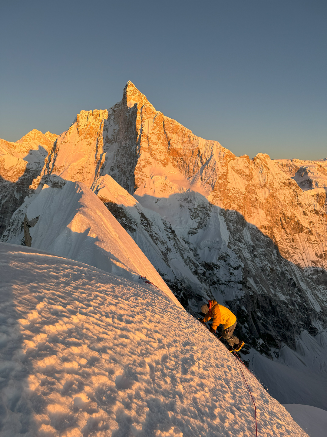 Hiroki Yamamoto descends from the summit of Phole. Jannu catches the setting sun, with the north face in profile and the west pillar facing the camera.
