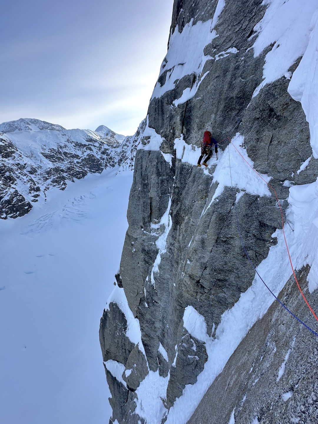 Dane Steadman traversing left after a pendulum to bypass the scariest snow mushroom on In the Shadow of the Wall. 