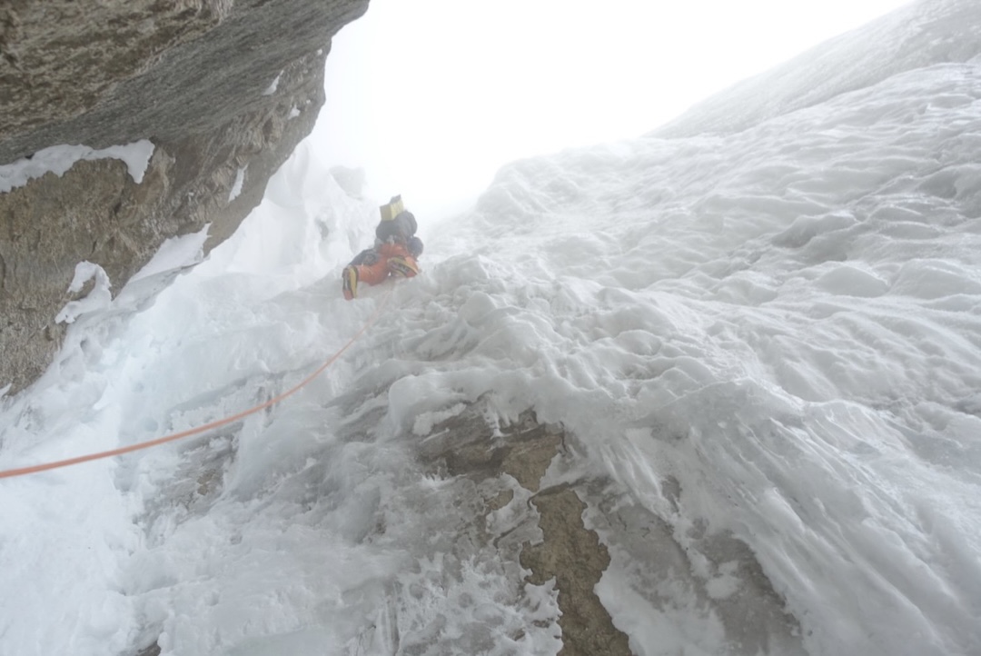 On a stormy day three of his Gašper Pintar’s ascent of The Great Wall on Mt. Dickey, Tom Livingstone climbs steep ice and névé.