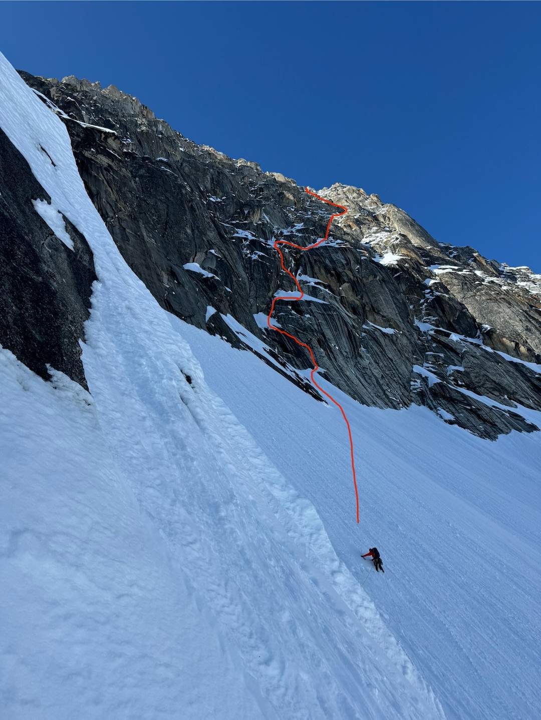 Michael Telstad traversing the upper snowfield toward the center of Mt. Bradley’s southeast face, with the line showing part of the complex route of Sports on the upper face.