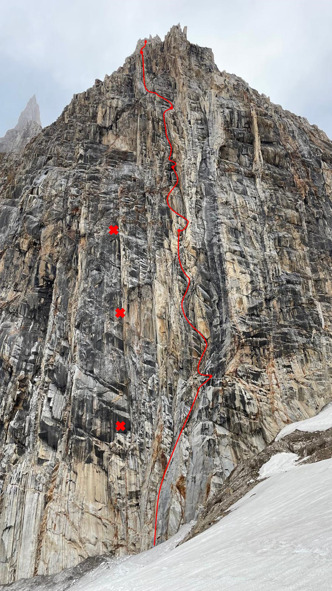 The southeast pillar of Sosbun Spire III (Mun Brakk II). A foreshortened view of the 2024 route, Izar Gorri, Mamuon Betiko Argi, is marked. The three dots to the left mark ancient bolts of unknown origin (likely rappel anchors) spotted during the ascent. 