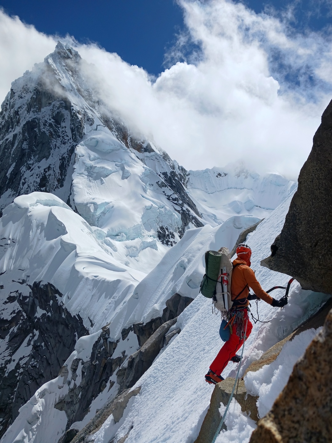 Tucker Merrill near the top of Taulliraju Sur (ca 5,400m). From this summit, the pair traversed toward Taulliraju and bivvied on the snow beyond the saddle visible to the left of Merrill. The next day, they continued up the southeast face and ridge of Taulliraju. 