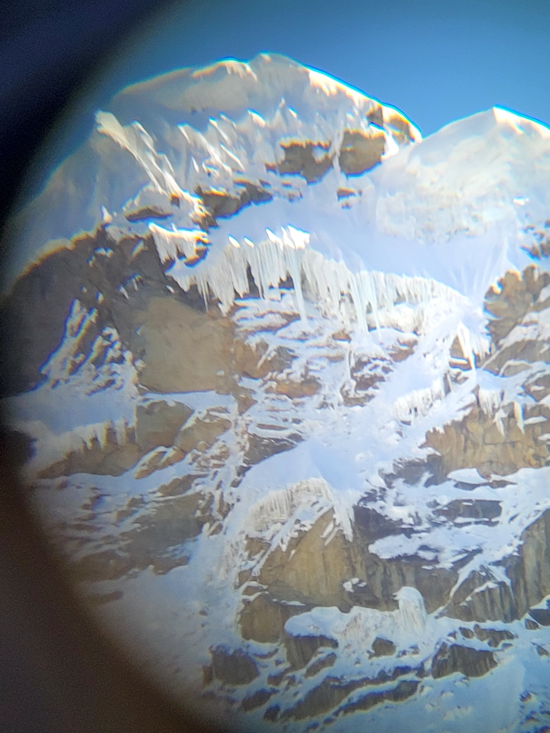 Monocular view of the upper south face of Nevado Copa. The 2024 route A la Sombra de la Duda weaved up ramps to pass the seracs. 
