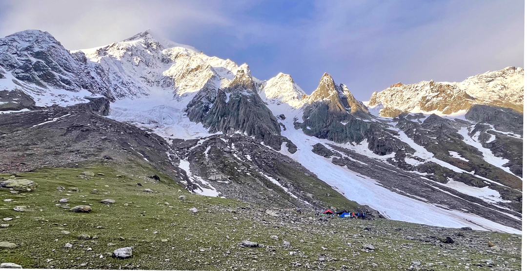 Base camp below the south face of Brammah. A foreshortened view of the mountain shows the couloir climbed in 2024, slanting left from directly above the tents. 