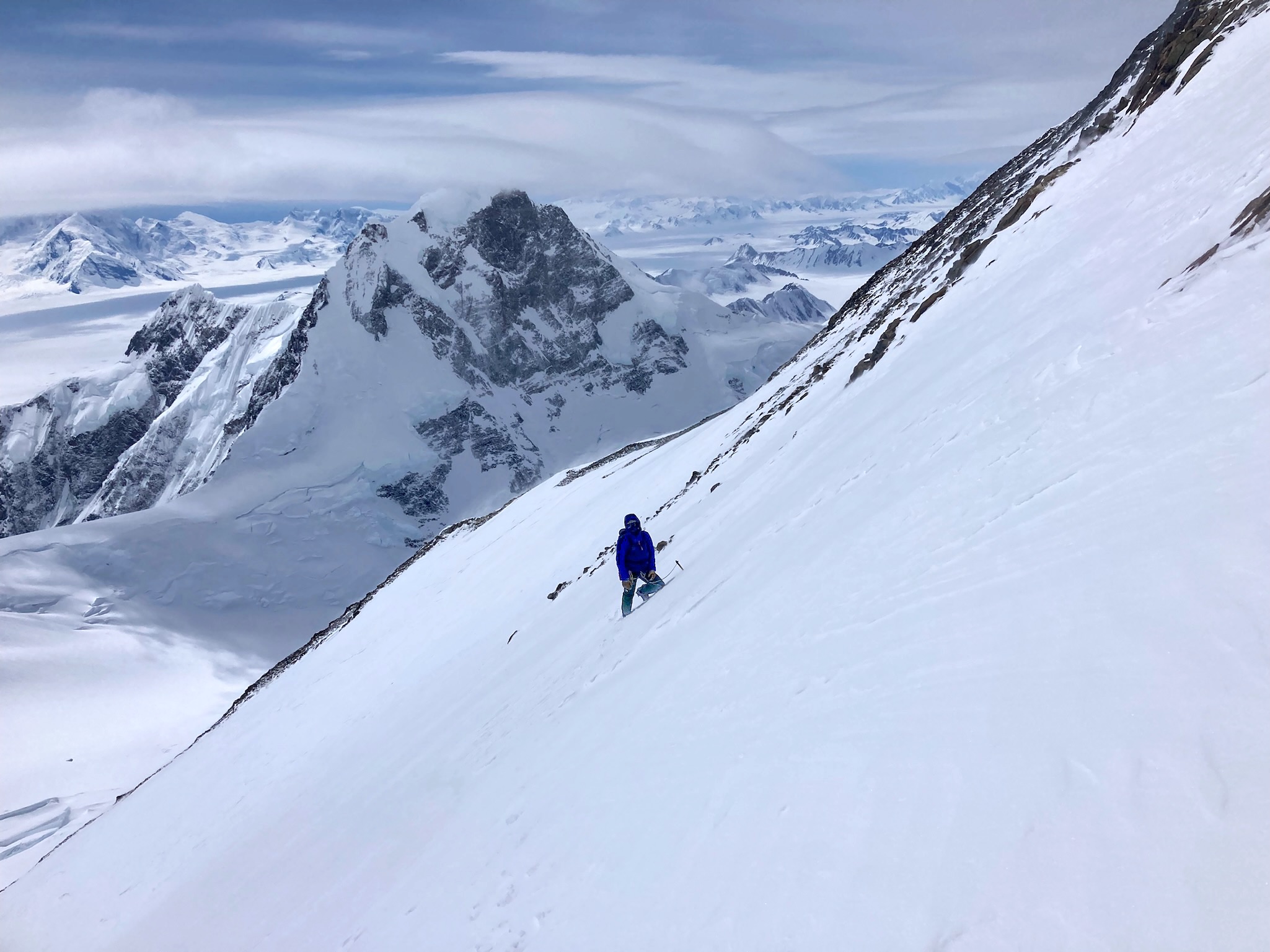 Ryan Driscoll on the snowfield leading to the upper gullies on the south ridge of Queen Peak. In back is the unclimbed north face of King Peak (5,172m).