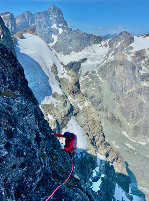 Katie Beringer nearing the top of pitch nine on the northeast ridge of Tsini Tsini Peak, with the Horn in the distant background.