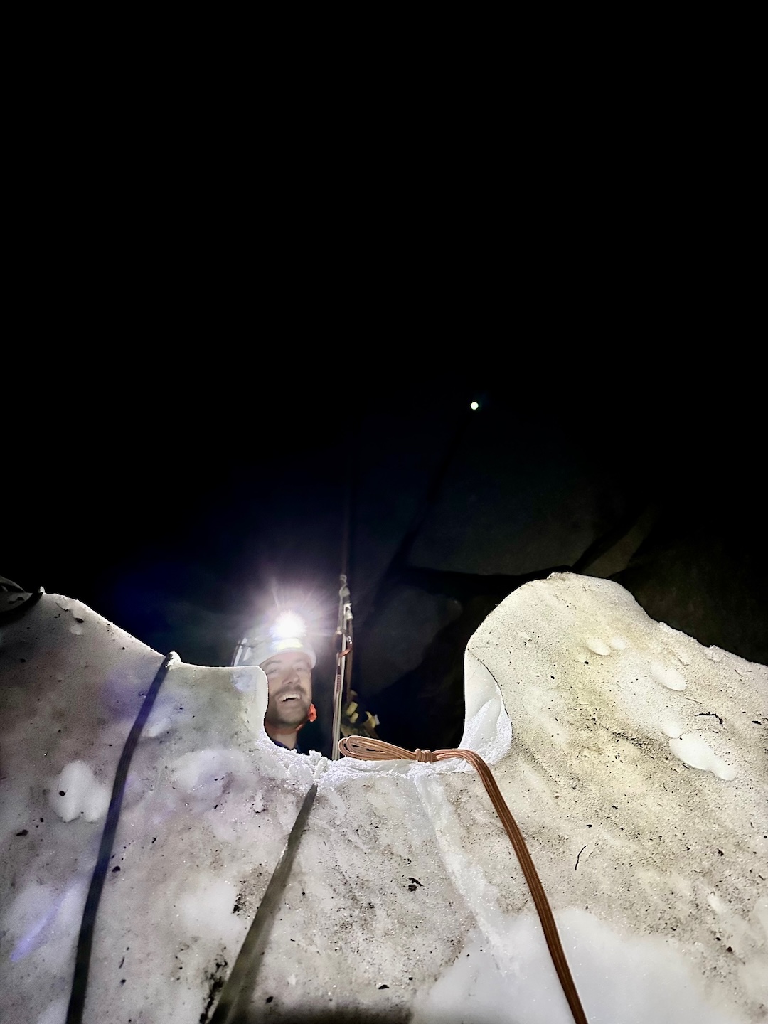 Lowering out through the moat below Snowpatch Spire off a buried wooden CMH Heli stake.