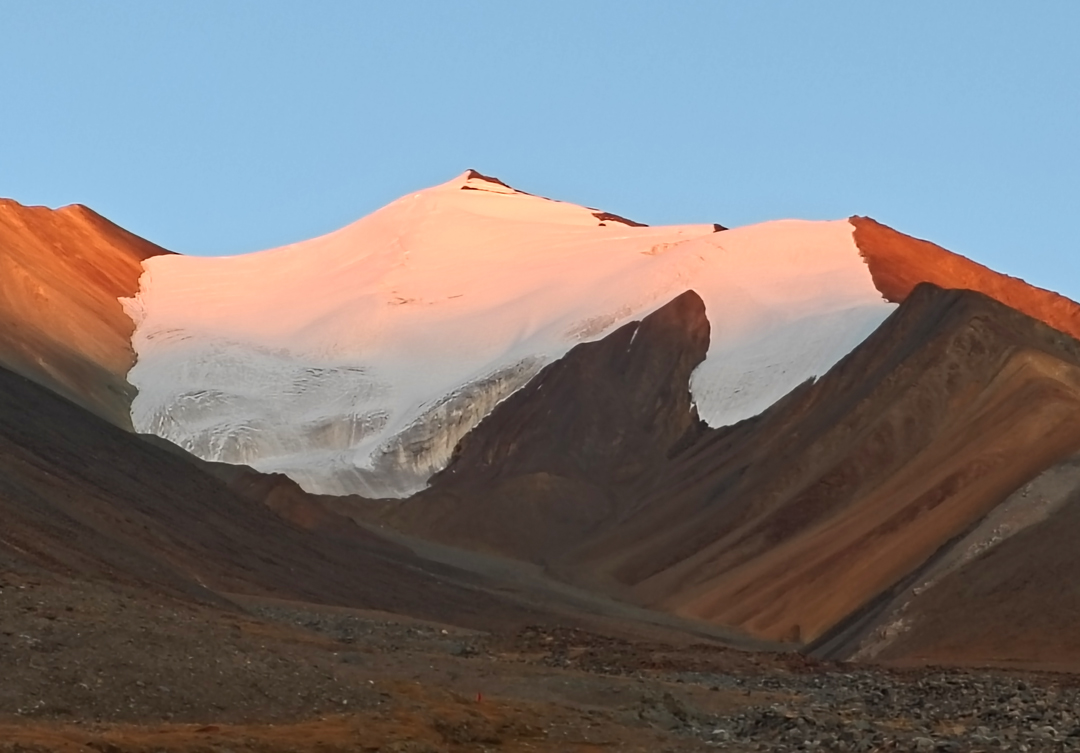 The northwest flank of Peak 6,128m from the upper valley. The ascent route followed the left side of the glaciated slopes to the ridge (summit camp) then up the crest (right) to the summit. 
