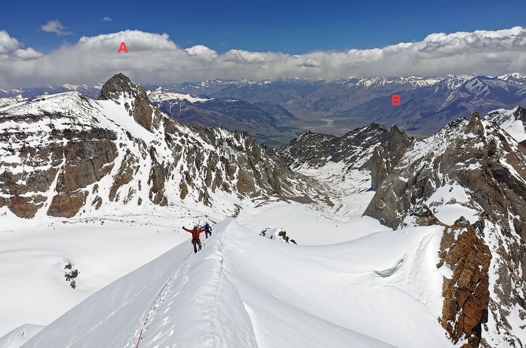 On the summit ridge of Vajrayogini (6,095m), climbed by the northeast face and northwest ridge. Below is the Rangtik Glacier and in the distance (A) Remalaye (6,278m) and (B) Jamyang Ri (5,800m).  
