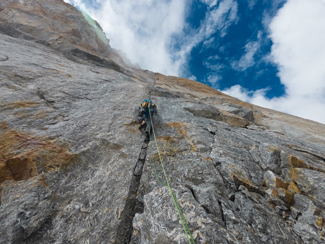 Aid climbing on the new route Namyang MeJet (400m, 11 pitches, UIAA VII A2 60° ice) on the northeast face of Chanrasrik Ri North. The crack system was very thin and often closed, requiring birdbeaks and micro cams. Snowfall on the first morning left the wall completely wet, making free climbing impossible. They descended after reaching the ridge, but earlier in the trip summited Chanrasrik Ri’s central top and made the first ascent of the main summit. 
