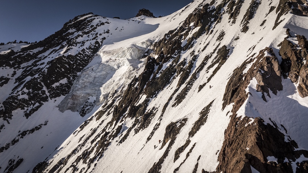 Nicolás Gutiérrez, Alexis Rojas, and Cristóbal Cament approaching camp two on the south face of Cerro Tronco, above the steep lower wall. 
