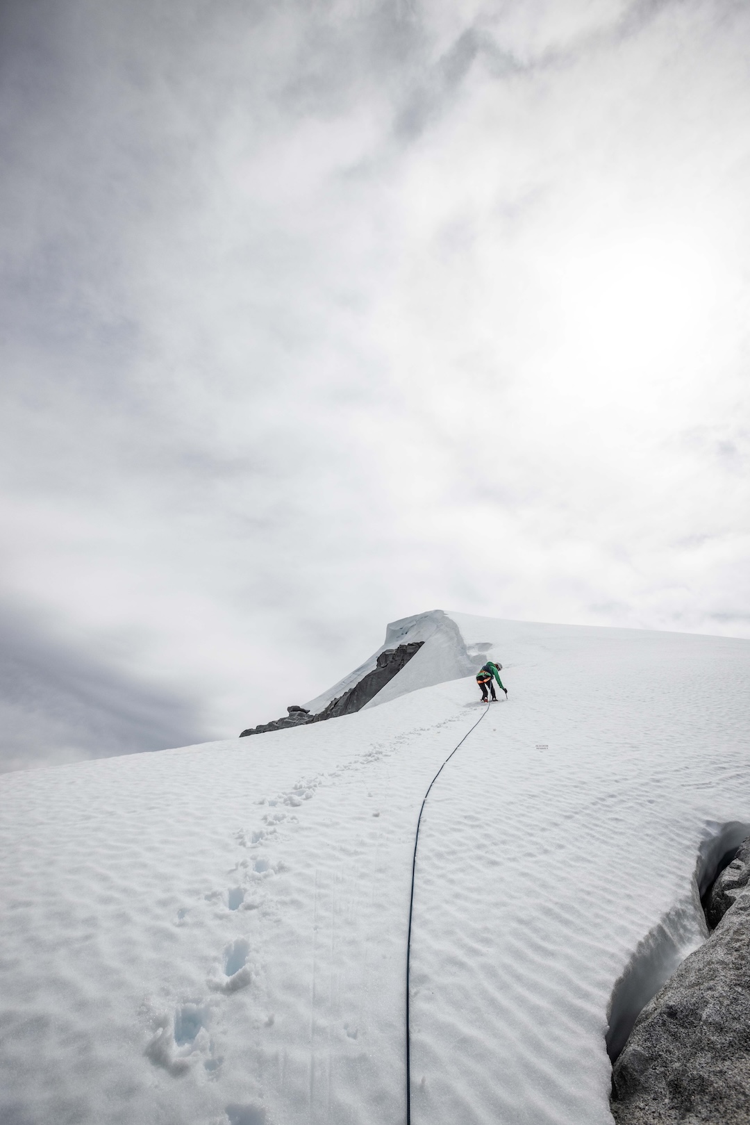 Fay Manners climbing toward the first snow summit above the rock wall on El Cohete.