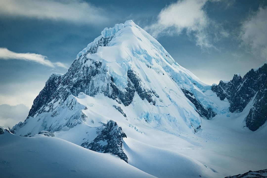 The south face of Cerro Ambrosio Oeste, as seen from Refugio O'Higgins. Thor Retzlaff and Matthew Tufts' descent follows the summit down the arête over the steep roll, gaining the ramp that splits the seracs before a 45m rappel through the lower glacial serac wall at far looker's right. 