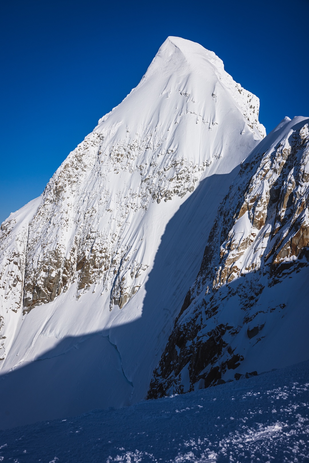 The "dream line" on the fin-like southern summit of Cordón Ilse Von Renztall. The summit is slightly overhung (in classic Patagonian mushroom rime form), and the line from the col featured exposed glacial ice of greater than 60°, so Fer Ferrandez and Matthew Tufts opted for a skiable couloir to climber's right of their initial vision. 