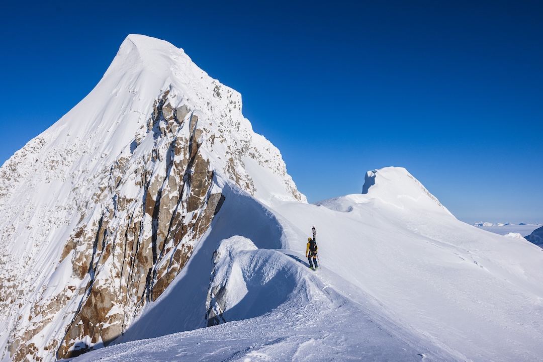 Fer Ferrandez traverses the lower ridge of Ilse Von Rentzall after topping out a skiable couloir. The team descended slightly onto the north aspect before finding an M4 passage to the col that connects to the summit arête, rather than traversing an unprotectable slab-rock ridge in loose dry powder snow. 