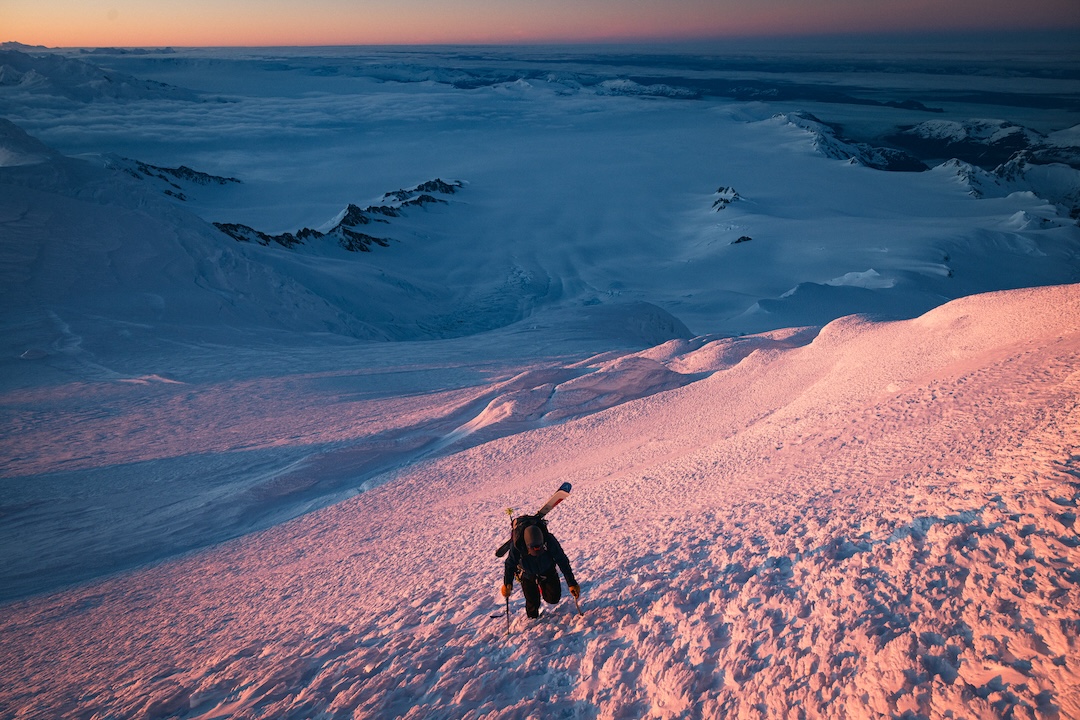 Thor Retzlaff climbs at sunrise through Lautaro's infamous sastrugi and rime with Pacific fjords looming in the clouds below.