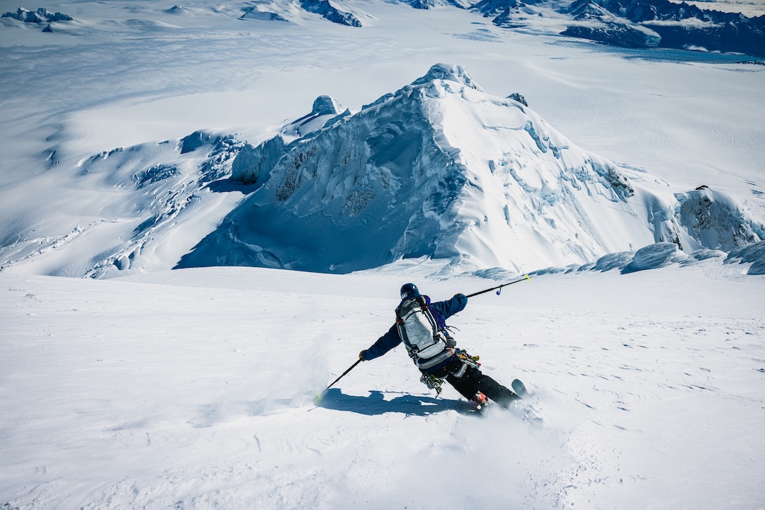 Thor Retzlaff carves into perfect chalk conditions on the immense headwall of Volcán Lautaro's north face with Cerro Mimosa and Cerro Pangrec below. The total relief of the north face is more than 2,200 meters above the Southern Patagonian Icefield. 