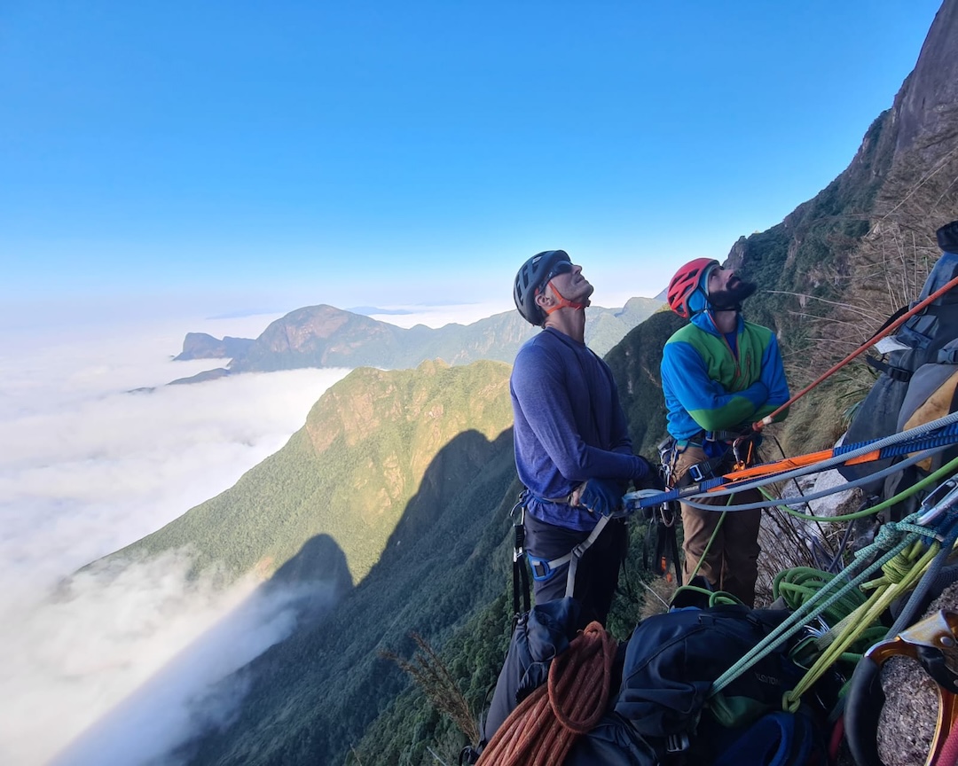 Willian Lacerda (left) and Daniel Covatti at their anchor above a sea of clouds during the first ascent of Submundo das Sombras (655m of climbing, 7a A2), on Pico do Paraná. 