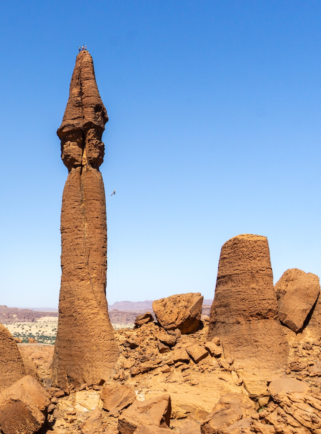 Dakota Walz, Sam Stuckey, and Natalie Afonina take in the view from atop a 65-meter sandstone tower in Chad’s Ennedi Massif, while Bosco Bonilla descends. The formation was climbed in two pitches at 5.9 PG. 