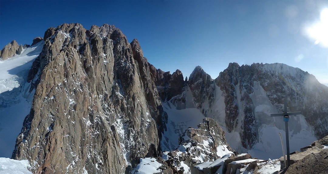 The view from the summit of Ak-Too Peak, looking generally east across the Ak-sai Glacier, with the rocky towers of Korona prominent on the left and the rounded summit of Baylyan Bashi in shadow on the right.