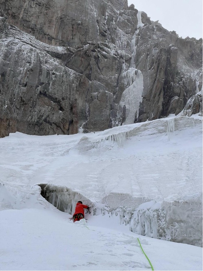 Maxim Popov below the west face of Verniy Peak, with the ice line attempted in 2024 obvious above.