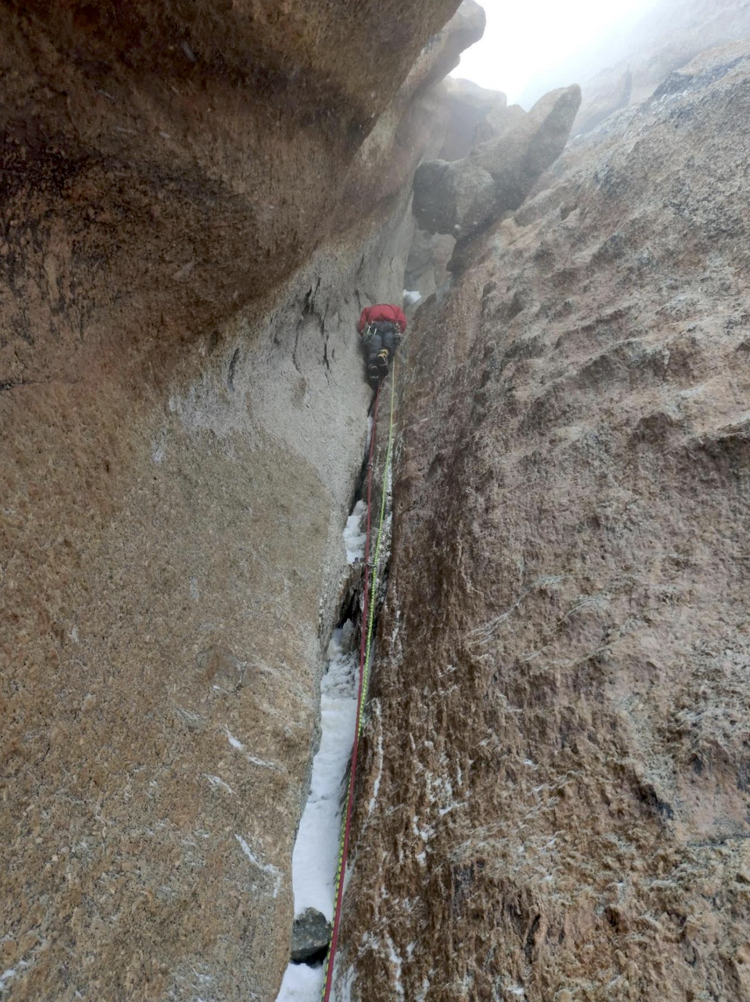 Stormy conditions in the chimney section at the middle of the 2022 route up the northwest face of Verniy Peak.