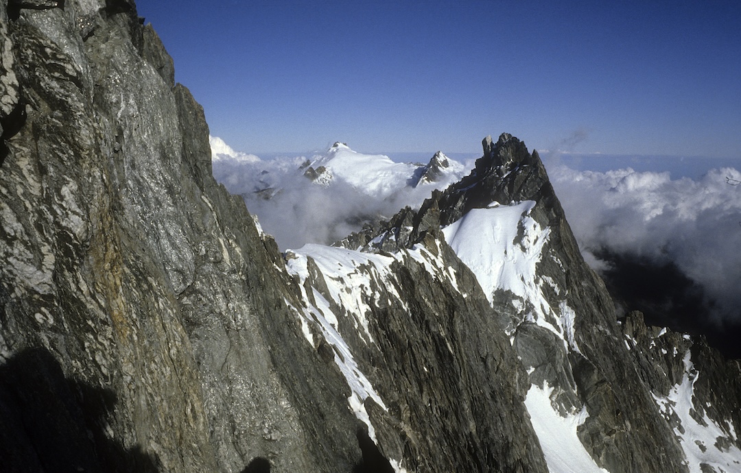From close to the top of Pico Bolívar, looking east along the connecting ridge to Abanico in December 1985. The gap before it is reached via the Garganta Bourgoin; the snow slopes of this wide couloir are visible at the bottom of the picture. Left of Abanico is Pico Bonpland, and left again Pico Humboldt. Forty years later, the glaciers visible here are all gone. 
