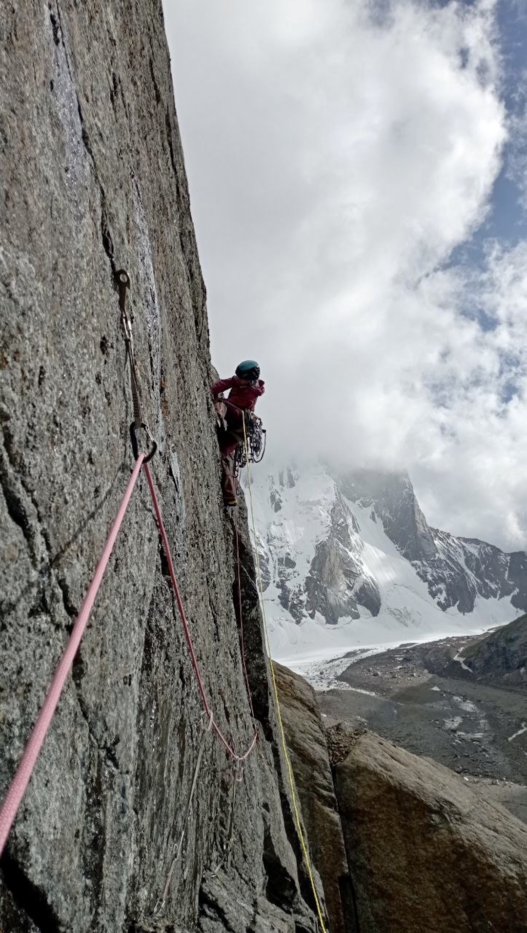 Anastasia Kozlova on the southwest face of Parus West, with part of the north-facing Ashat Wall behind. 