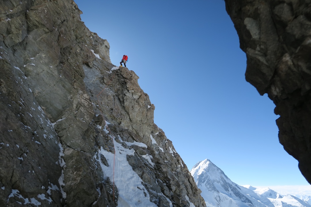 Tom Livingstone on the opening pitch of the west ridge of Gasherbrum III. In back is the final pyramid of Gasherbrum I (8,080m), seen from the north. The standard Japanese Couloir route finishes up the sunlit slopes on the left.