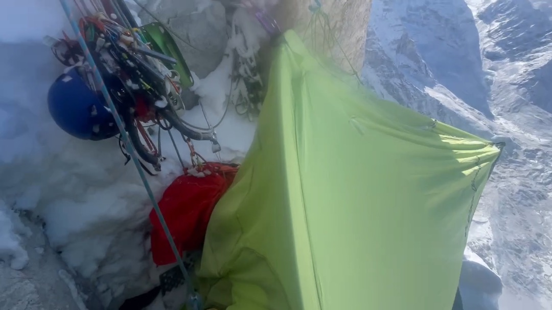 The cramped, sloping bivy site in the middle of the headwall on Kagur Kangri. “A sharp piece of ice sliced the tensioned ice hammock as we loaded it. Then one of our tent poles snapped. But we still had enough room to curl tightly on our sides.” 