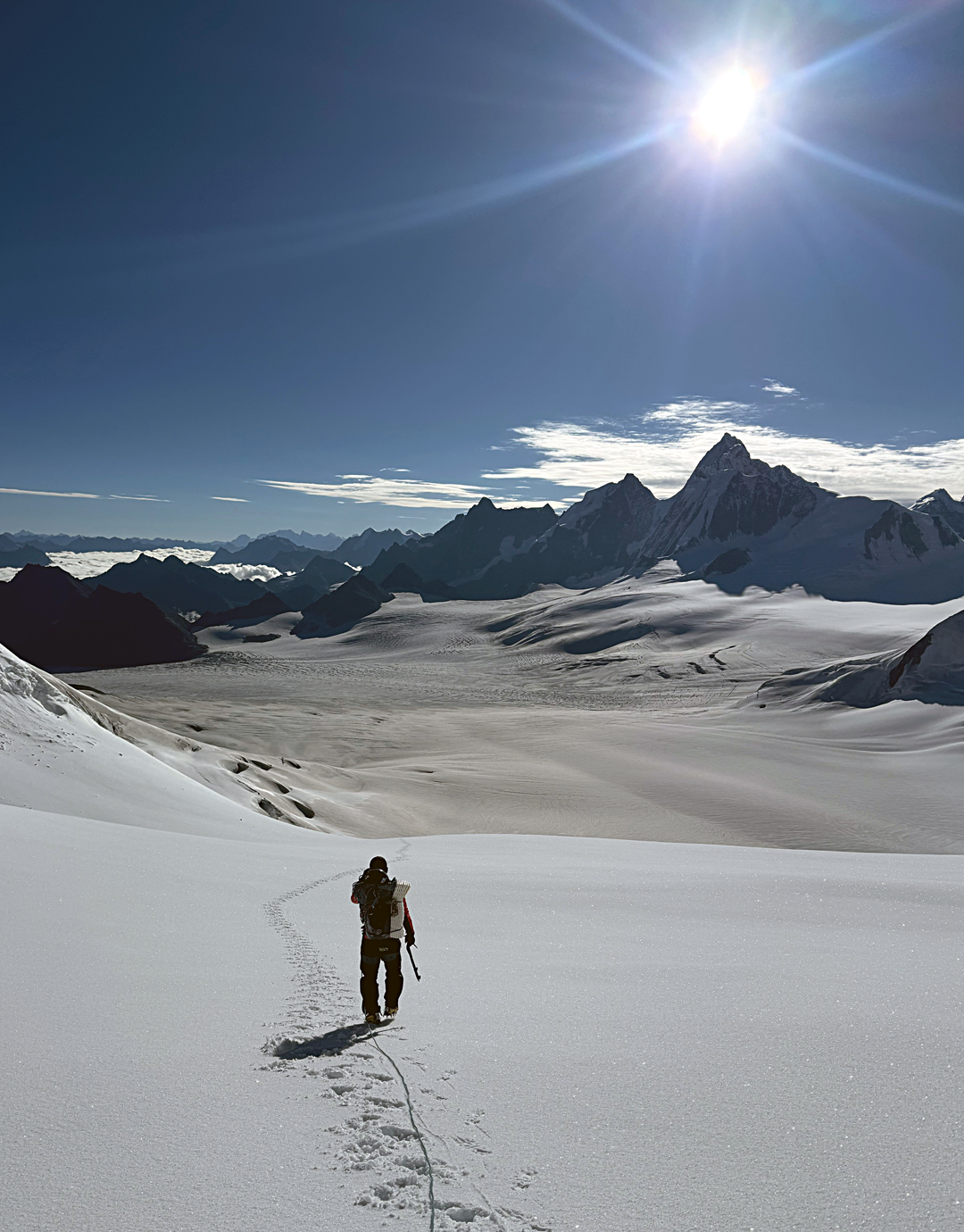 Descending the upper basin of the Aigagon Glacier. To the east, the high, pointed peak is unclimbed Nenang (6,870m). 