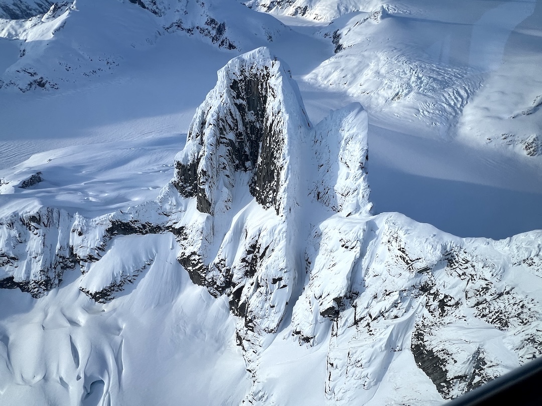 The West Tower (left) and the smaller Second Tower (a.k.a. Midget) in the Mendenhall group, seen from the south during a flight on February 14, 2024. The first winter ascent of the Second Tower took the obvious gully to the notch between the towers, then the west ridge to the summit. 