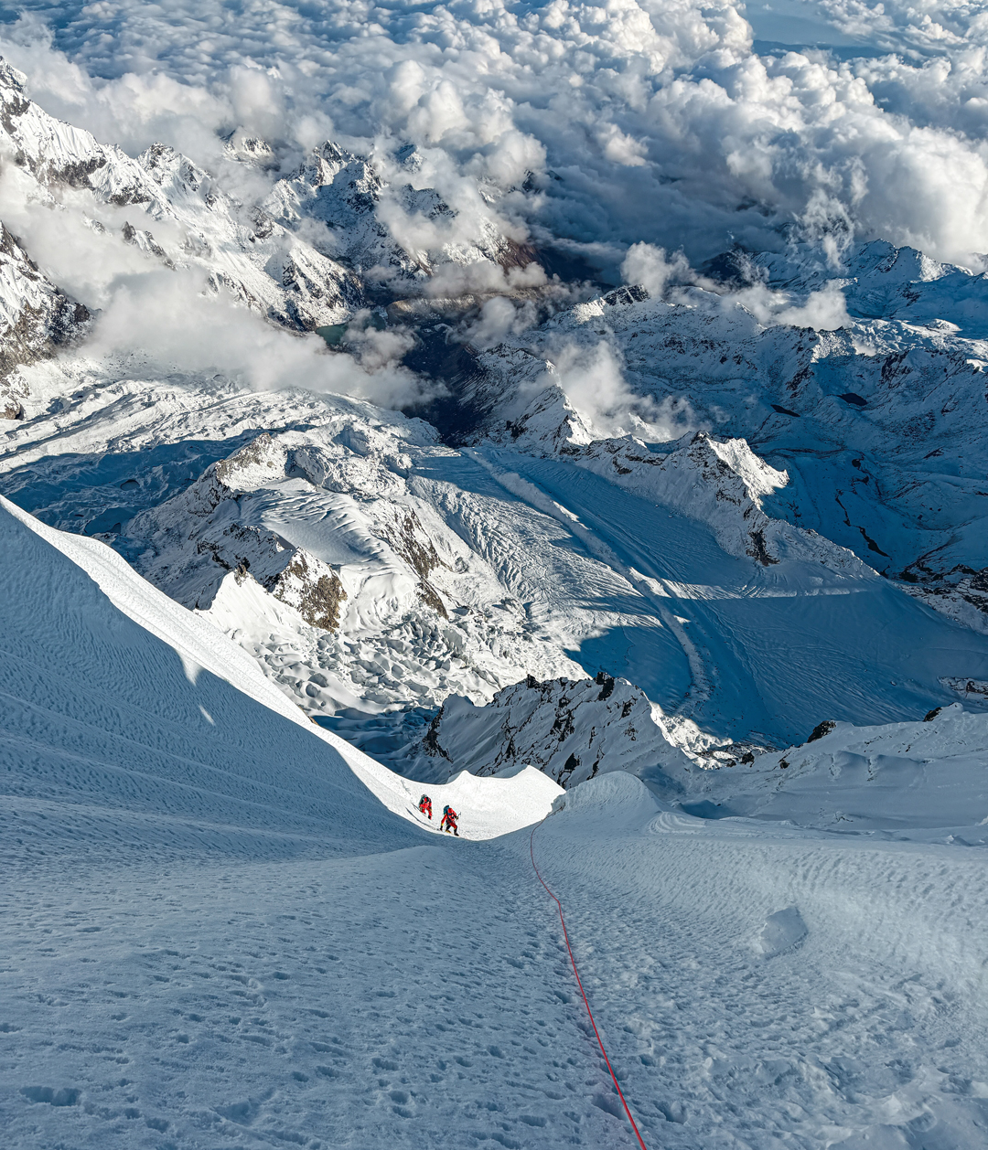 Adam Bielecki and Felix Berg heading toward the final section of the southeast face of Numbur with the Dudh Kund Glacier and Solu Valley below.