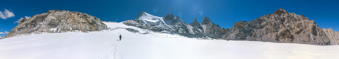 Ascending the upper glacier toward Sumna Himal (6,084m, the snowy peak above and right of the climber). Several rocky towers of around 6,000 meters separate Sumna Himal from Phasing (6,065m), the large rocky peak on the right, first climbed in 2018 from the far side by Julien Desécures, Grégoire Lestienne, Evelyne Miot, and Floriane Pugin. 