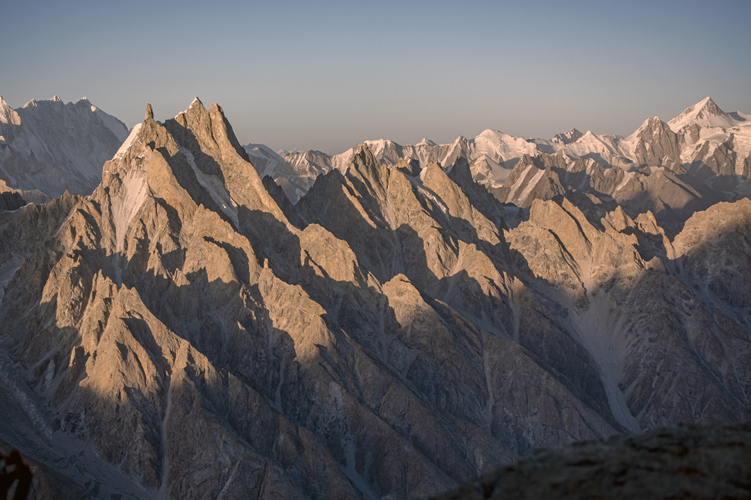The three summits of Suma Brakk (left), seen from the southwest. The 2025 first ascent of Suma Brakk West (a.k.a. Eye Ri) climbed the spectacular summit tower via the west ridge descending to the left. Behind and to the left are the Skamri peaks (6,773m). The lower rock peaks right of Suma Brakk, all below 6,000 meters, belong to the Choktoi Subgroup, while the high pyramid far right is Chiring (7,045m). 
