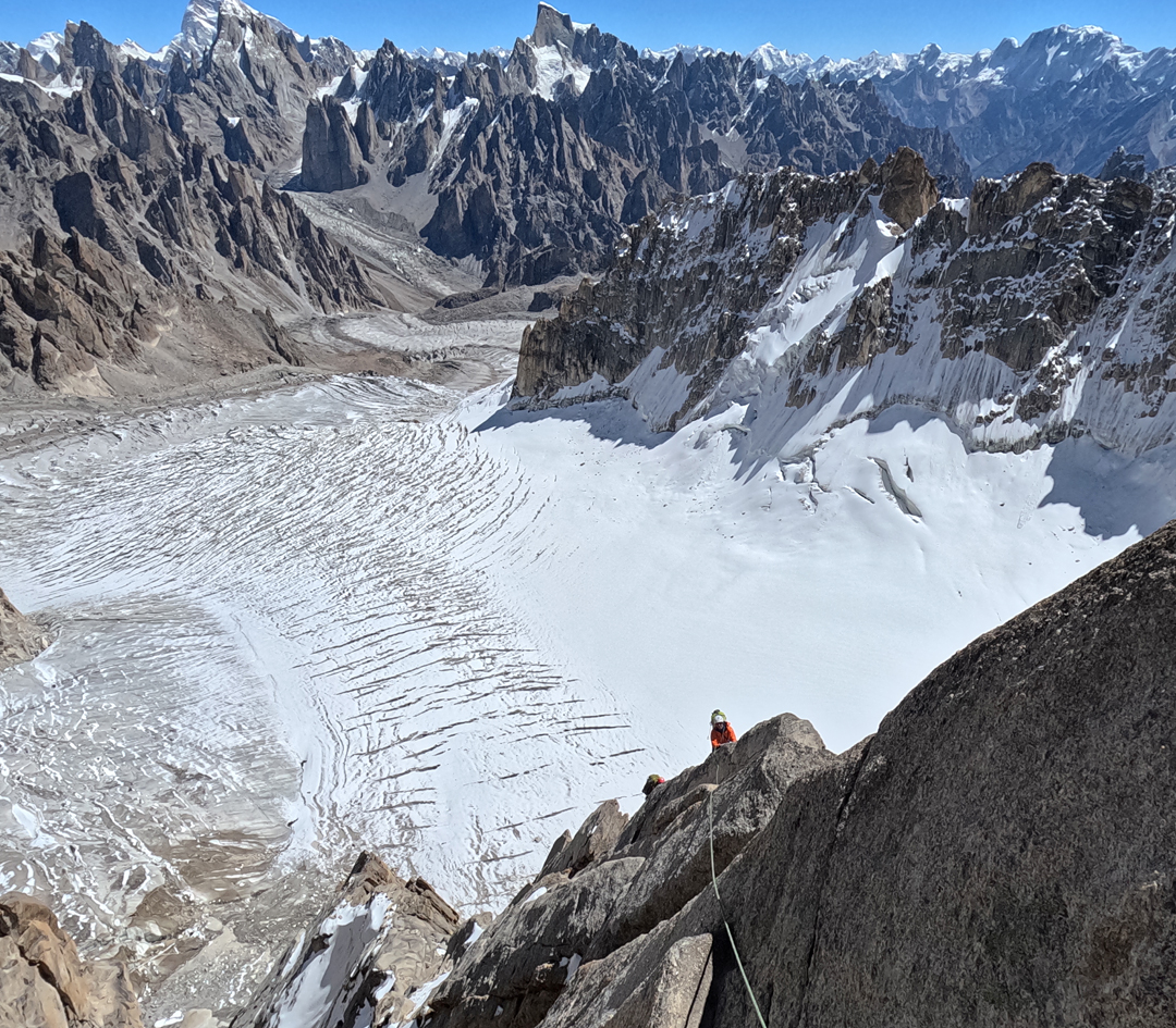 On the upper east pillar of Hasho Peak II (6,080m), with the West Lachit Glacier below, descending toward the Lachit Valley. In the background, the big peak on the left is locally referred to as Changi II (6,250m), climbed in 2018. The spectacular pointed peak in the middle may be Karmading Brakk, while the broad summit at the right edge of the image is Dansam. 