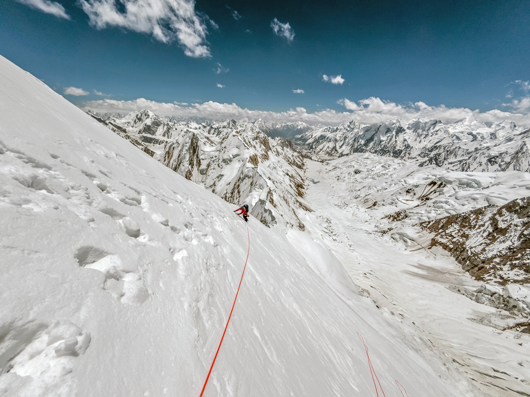 Mathieu Maynadier on day two of the climb on the east ridge of Spantik. Below and to his right is the Basin Glacier, and right of this is the long, lower, quasi-horizontal section of the southeast ridge (normal route) on Sapnitk. The peaks at distant right are part of the Haramosh Group.  