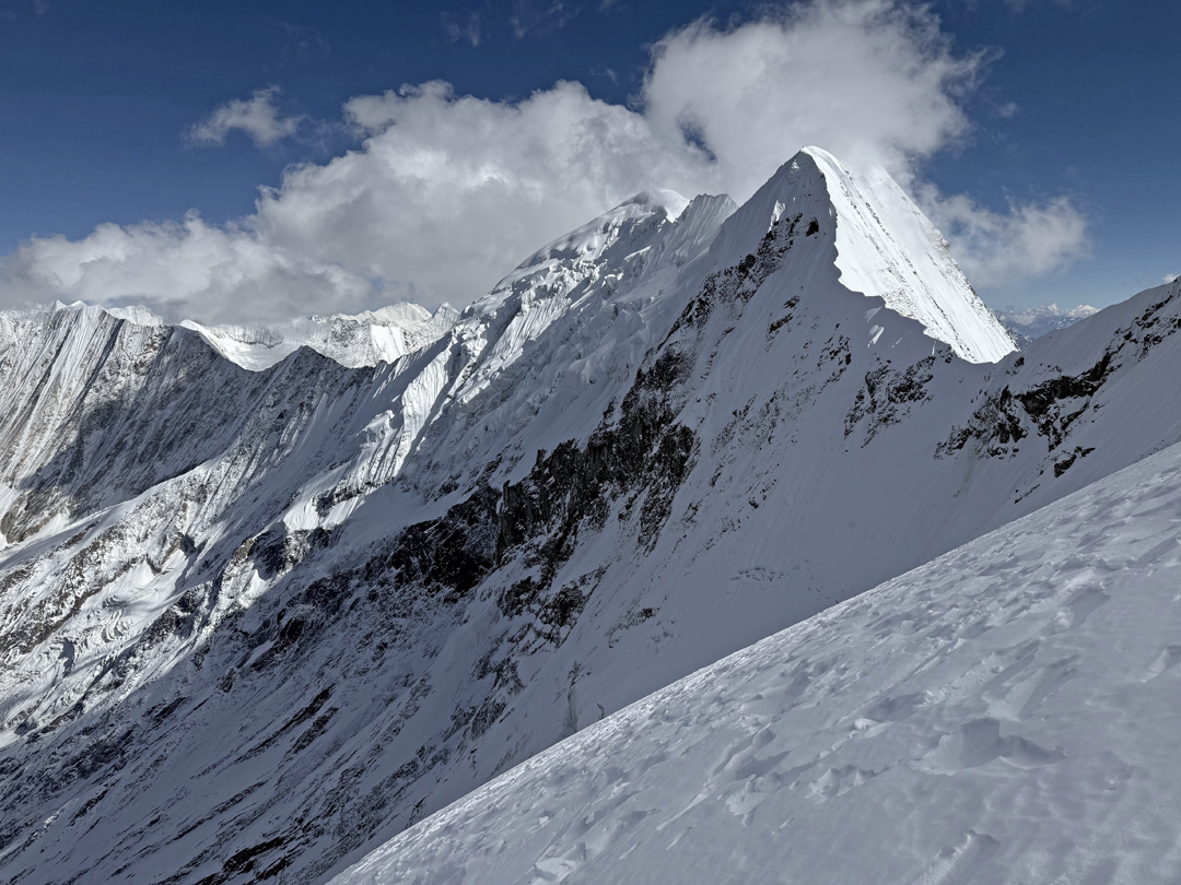 The view east-southeast toward Kasi Dalpha (the dome-like summit in the center of the picture). On the ridge closer to the camera is an unnamed, unclimbed top of 6,247 meters. 