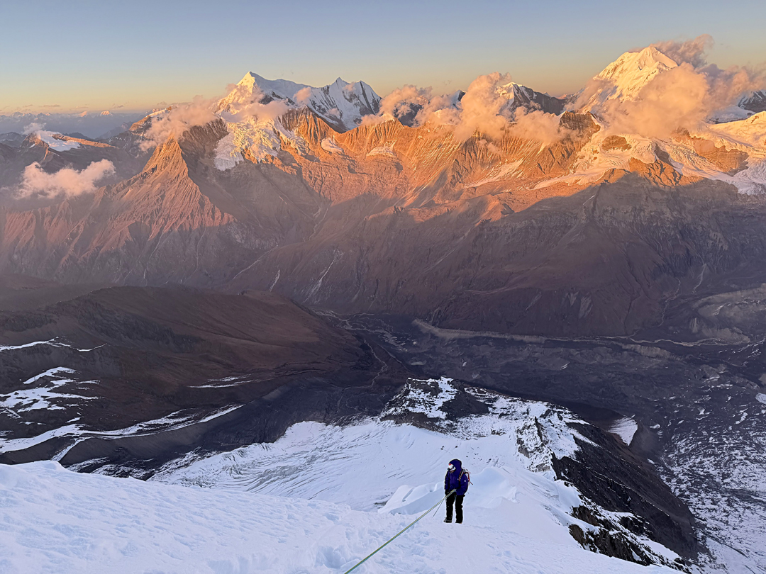 During the descent, at dusk, of the northeast ridge of Bijora Hiunchuli. Below, in the shade, is the Chaudhabise Valley. The sharp snow pyramid toward the left is Kande Hiunchuli (6,627m), from which a ridge extends north to the Patrasi peaks (Patrasi I, 6,521m). The large peak on the right is Kanjiroba (6,883m). 