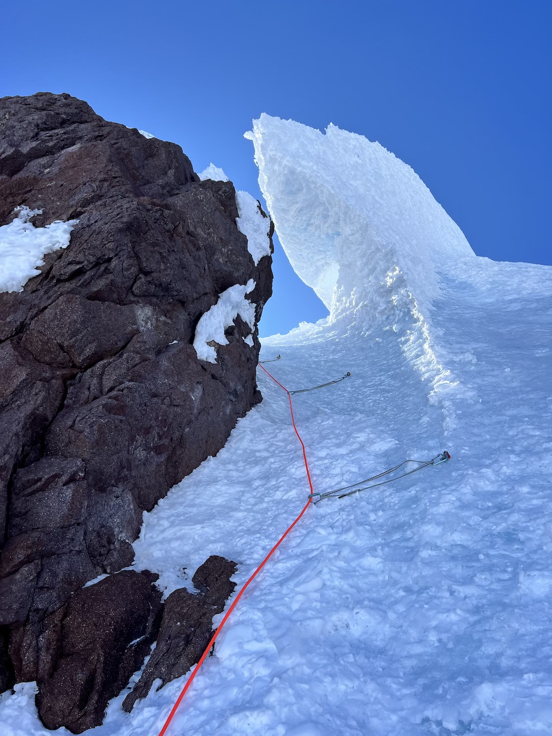Catalina Unwin leading blue ice under a hanging serac wave and finally to the summit plateau.