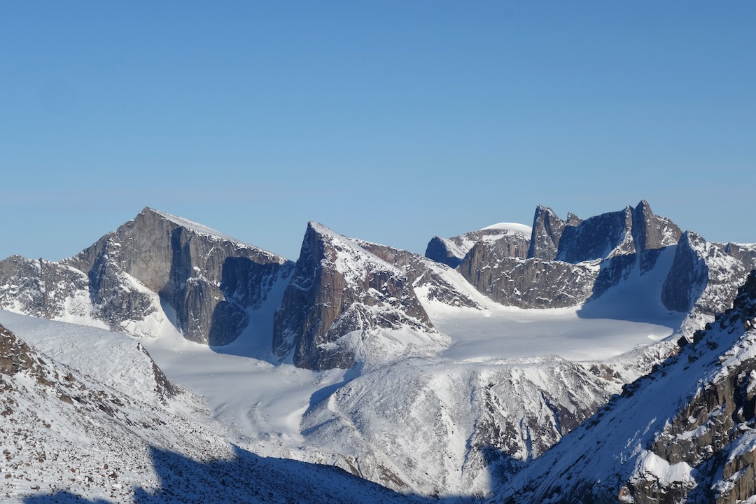 Unclimbed walls at 66.394361, -64.978635, roughly 25 kilometers from Kingnait Fjord, which is accessible by boat in summer. The photo is taken from the eastern side of the Fork Beard Glacier, looking approximately southeast. 