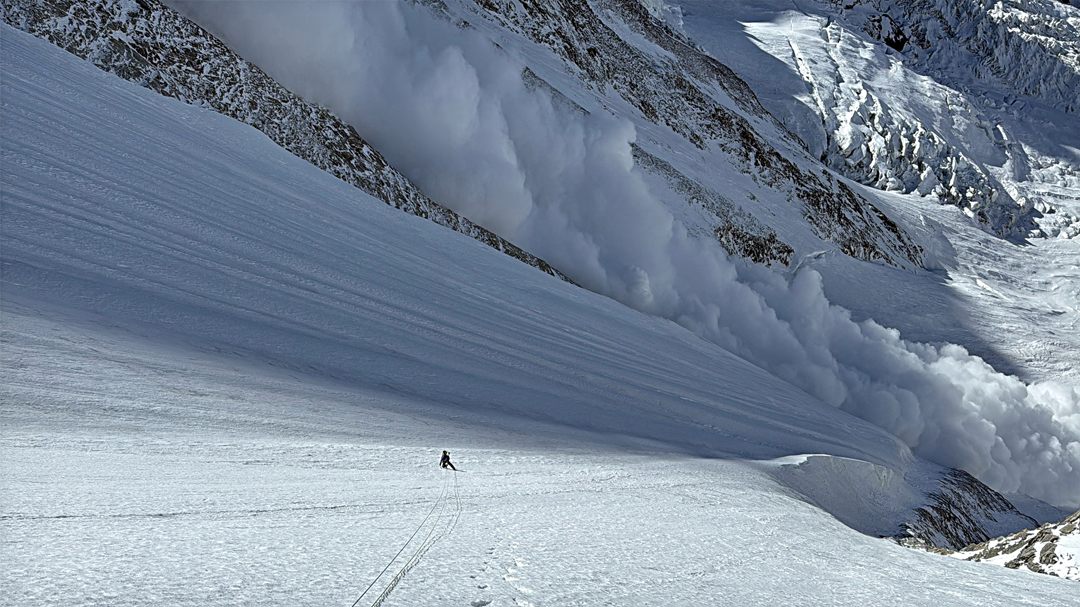 An avalanche descends to the upper Yanzigou Glacier from the north face of Minya Konka, west of climbers on the north spur. 