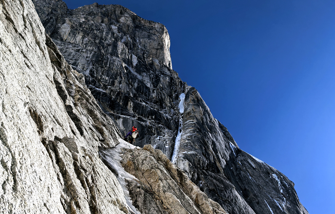 Traversing the west flank of the north ridge of Siguniang during the first ascent. The upper section of the ice couloir forming the Inner Line can be seen to the right.